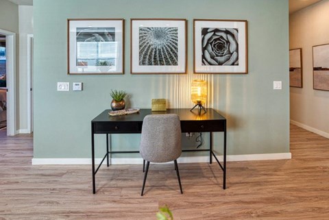a home office with a desk and pictures on the wall