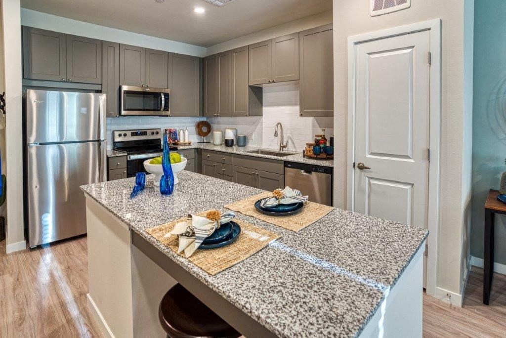 a kitchen with stainless steel appliances and granite counter tops
