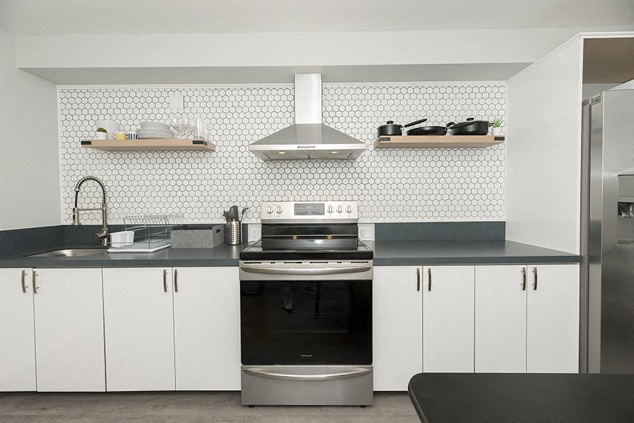 a kitchen with white cabinets and a black counter top