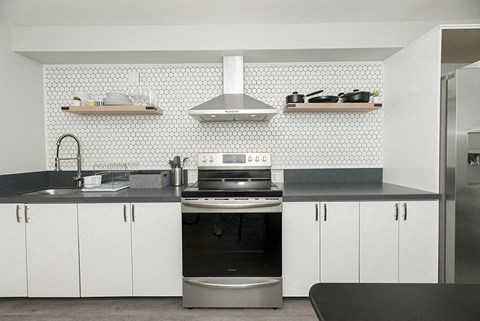 a kitchen with white cabinets and a black counter top
