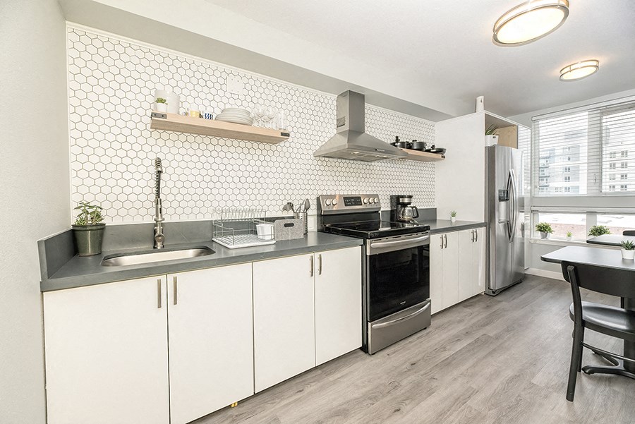 a kitchen with white cabinets and stainless steel appliances