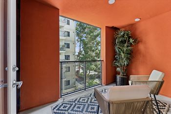 A balcony with a chair and a potted plant.