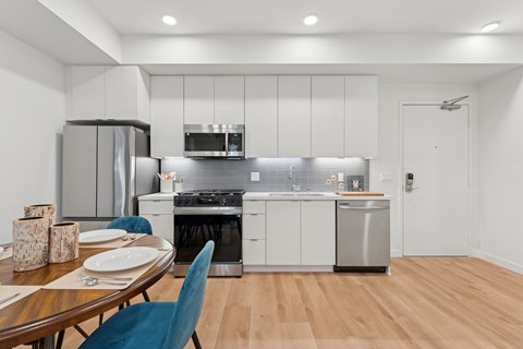 A modern kitchen with a dining table set for two.