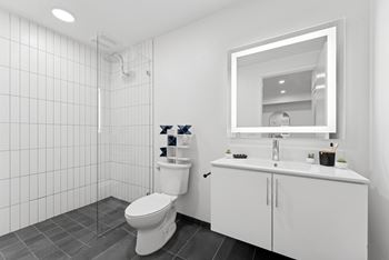 A white bathroom with a toilet, sink, and mirror.