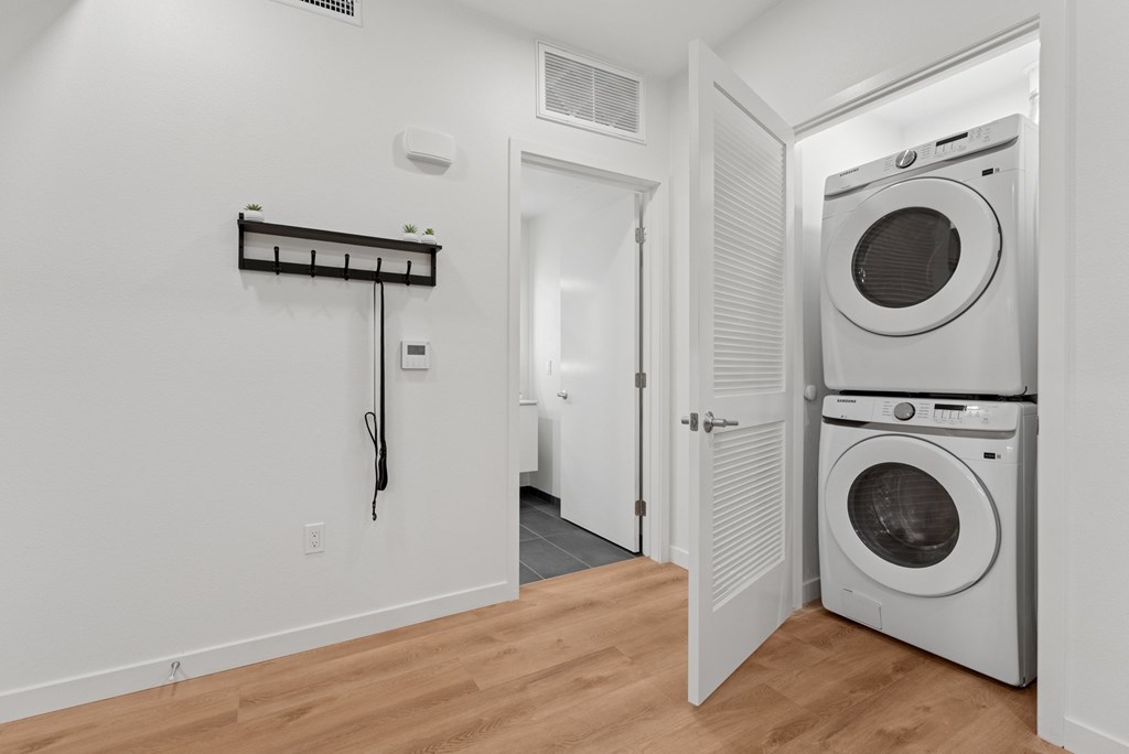 OnyxOnPark_SanDiego_CA_Model_1BR_ A laundry room with a washer and dryer.