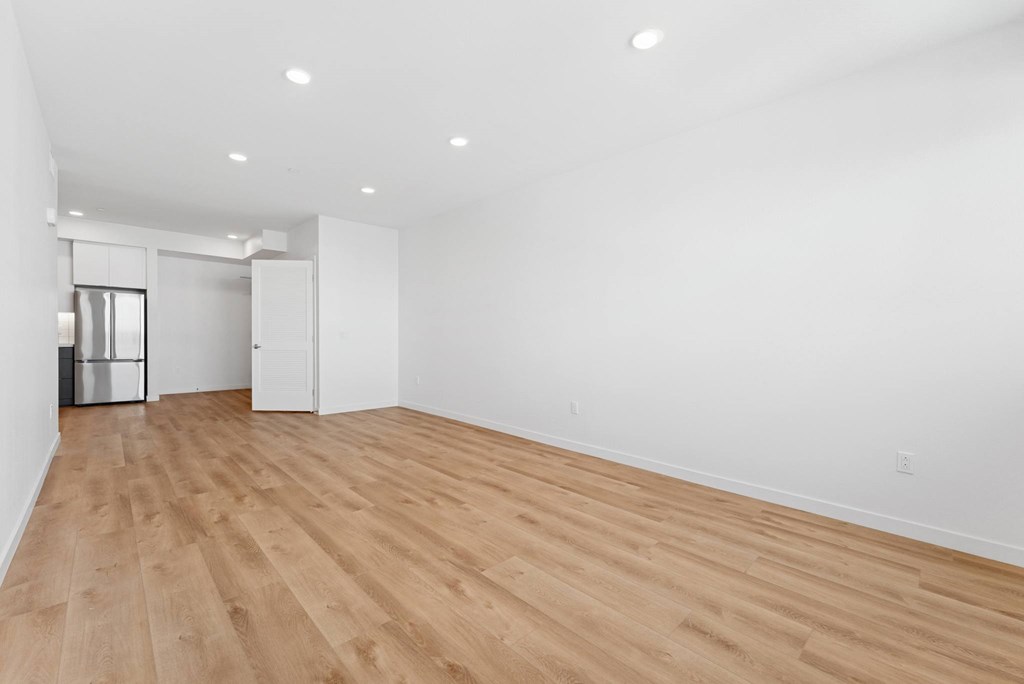 OnyxOnPark_SanDiego_CA_Vacant_2BR_ A room with wooden floors and white walls.