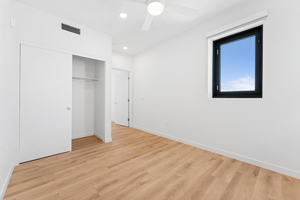 OnyxOnPark_SanDiego_CA_Vacant_2BR_ A room with a window and a ceiling fan.