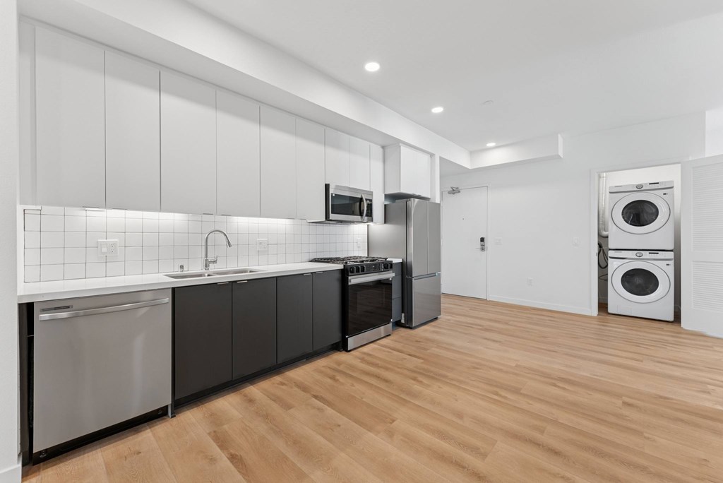 OnyxOnPark_SanDiego_CA_Vacant_2BR_ A modern kitchen with wooden floors and stainless steel appliances.