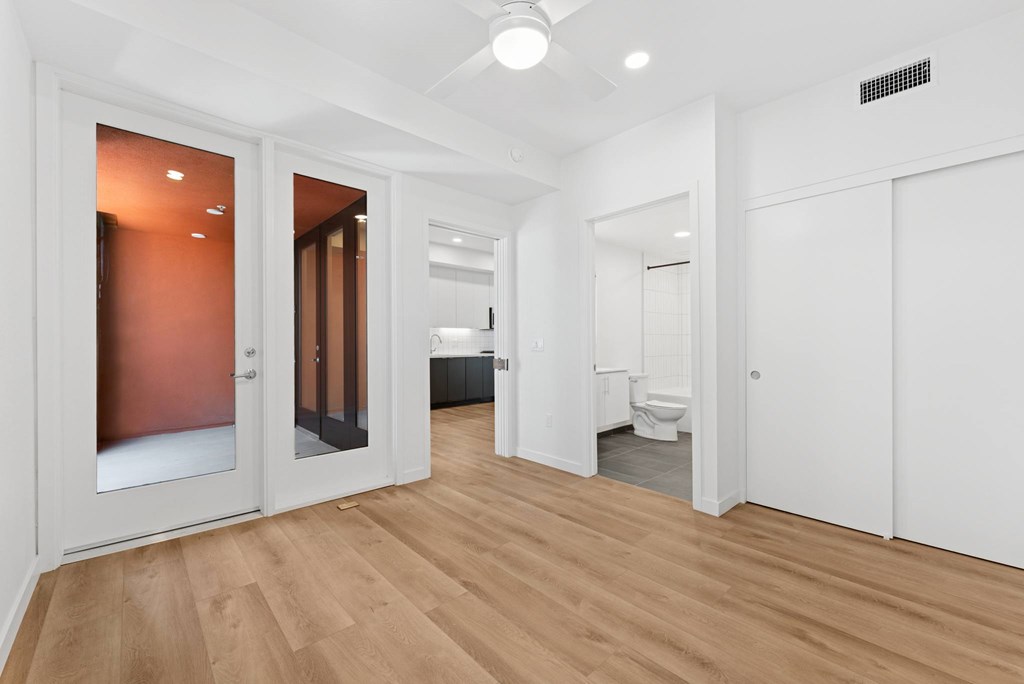 OnyxOnPark_SanDiego_CA_Vacant_2BR_ A room with a wooden floor and white walls.