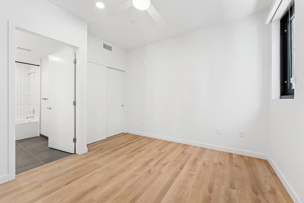 OnyxOnPark_SanDiego_CA_Vacant_2BR_ A room with wooden flooring and white walls.