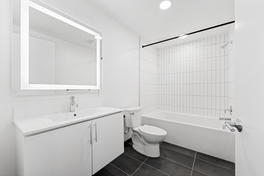 OnyxOnPark_SanDiego_CA_Vacant_2BR_ A white bathroom with a toilet, sink, and bathtub.