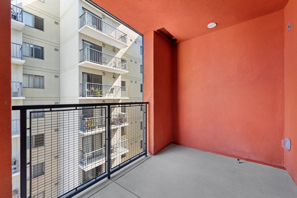 OnyxOnPark_SanDiego_CA_Vacant_2BR_ A balcony with a black railing and a red wall.