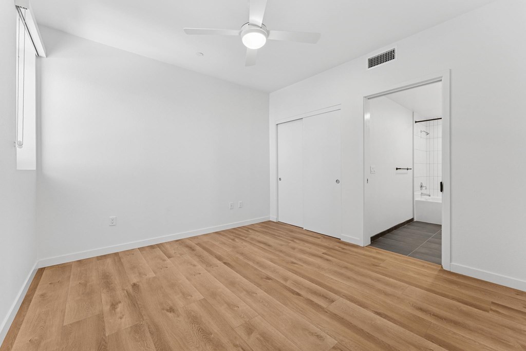 OnyxOnPark_SanDiego_CA_Vacant_2BR_B1_A room with a ceiling fan and wooden flooring.