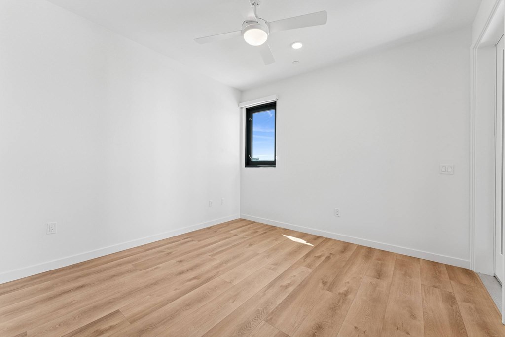 OnyxOnPark_SanDiego_CA_Vacant_2BR_B1_A room with a wooden floor and a ceiling fan.