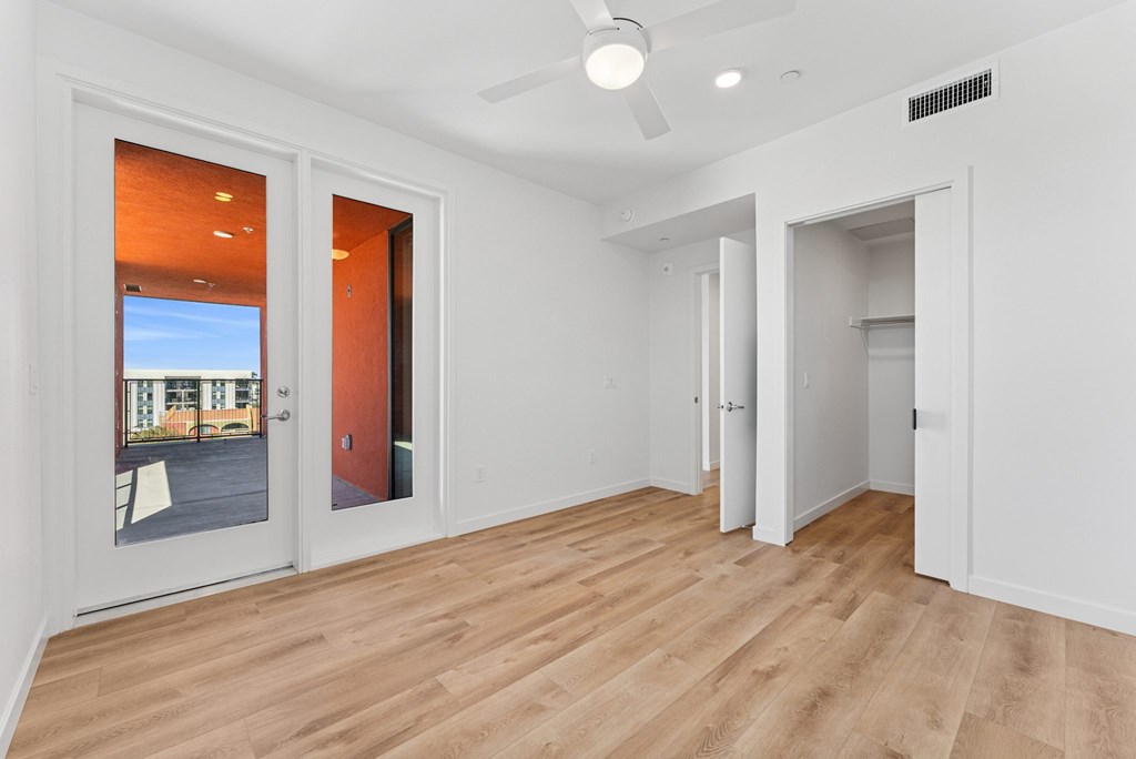 OnyxOnPark_SanDiego_CA_Vacant_2BR_B1_A room with a ceiling fan and a door leading outside.