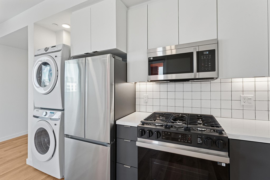 OnyxOnPark_SanDiego_CA_Vacant_2BR_B1_A modern kitchen with a stove, oven, and microwave.