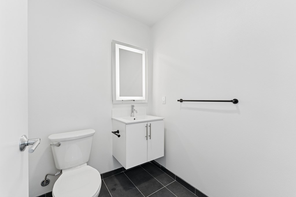 OnyxOnPark_SanDiego_CA_Vacant_Penthouse_A_OnyxOnPark_SanDiego_CA_Vacant_Penthouse_A_A white toilet sits next to a sink in a small bathroom.