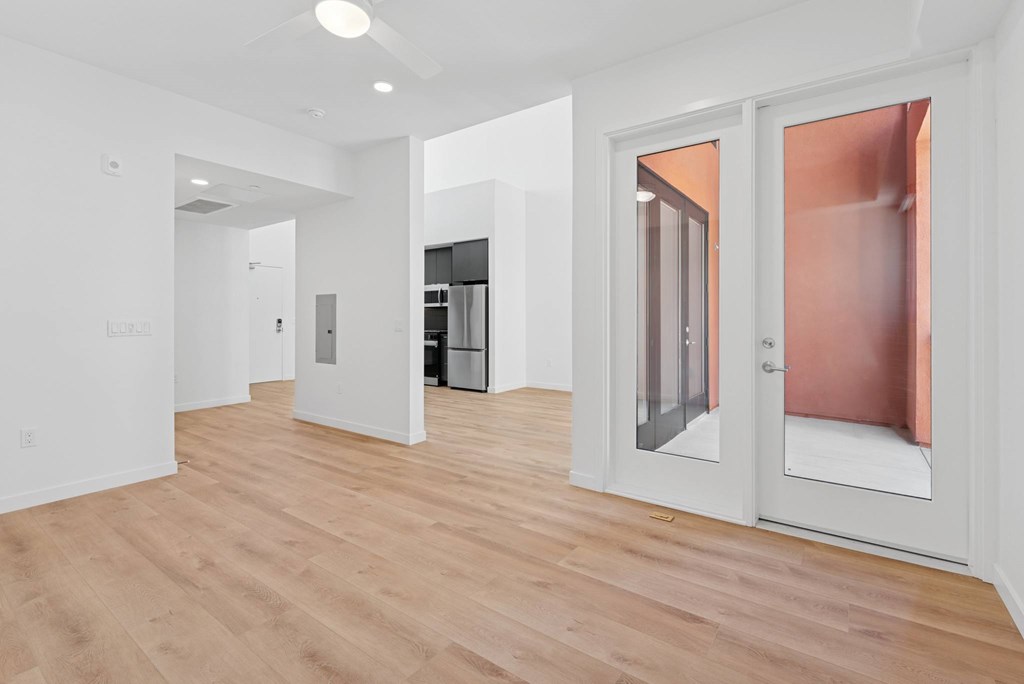 OnyxOnPark_SanDiego_CA_Vacant_Penthouse_A_A white room with a wooden floor and a glass door.