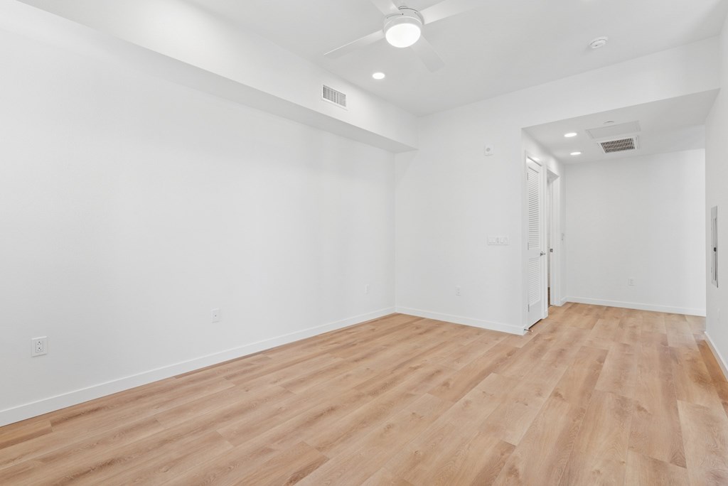 OnyxOnPark_SanDiego_CA_Vacant_Penthouse_A_A room with wooden flooring and white walls.