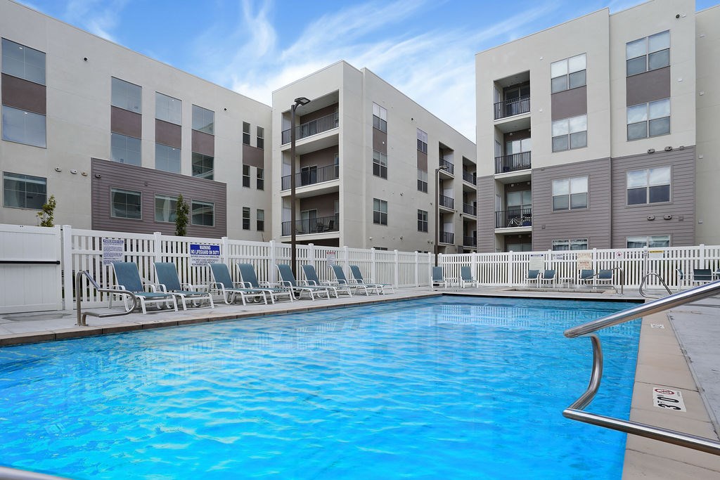 Alvera at the Meadows  swimming pool in front of apartment buildings.