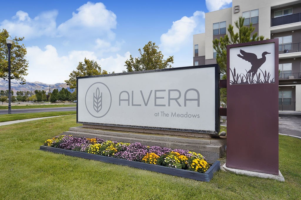 A sign for Alvera at The Meadows is surrounded by flowers.
