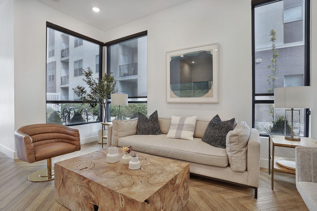 Alvera at the Meadows living room with a brown leather chair and a wooden coffee table.