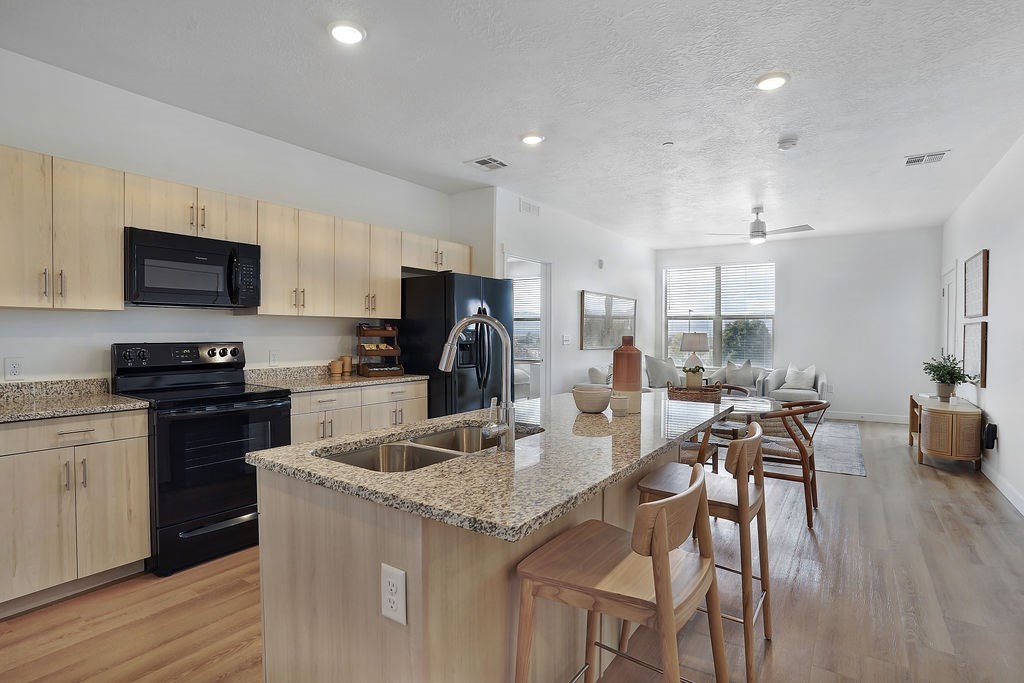 Alvera at the Meadows kitchen with wooden cabinets and a granite countertop.