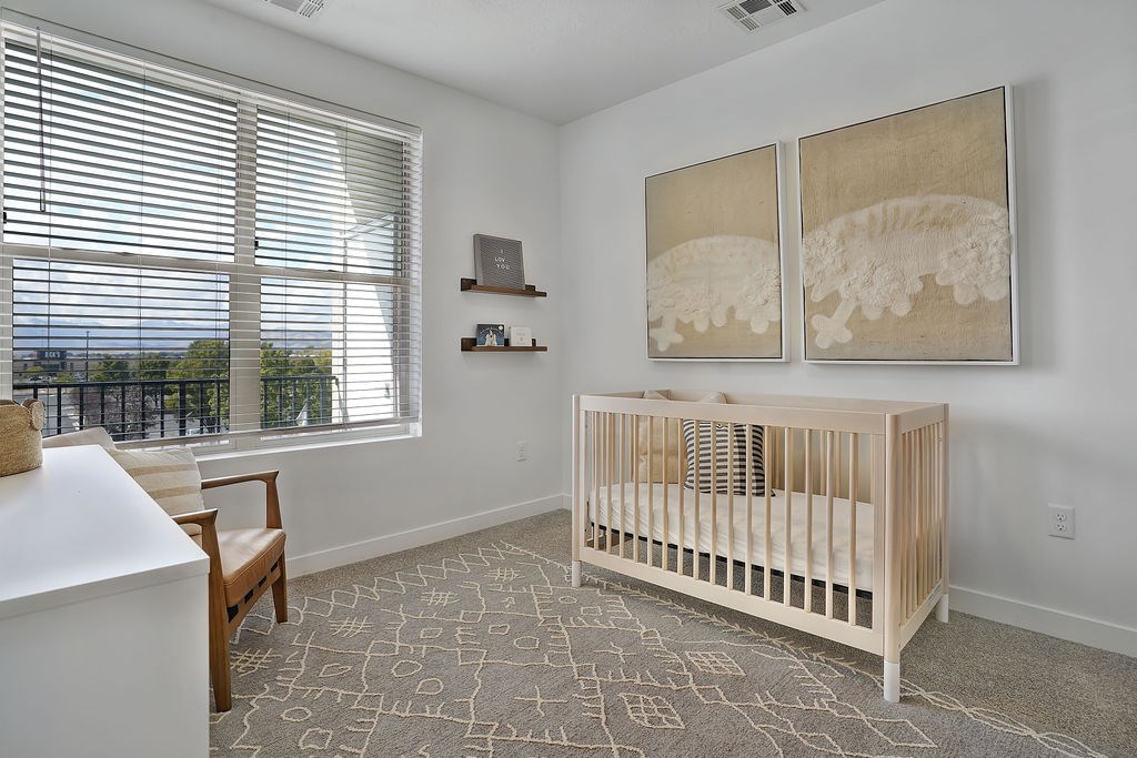 Alvera at the Meadows baby's room with a crib and a painting of a dinosaur on the wall.