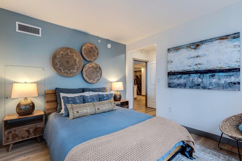 a bedroom with a bed and a painting on the wall