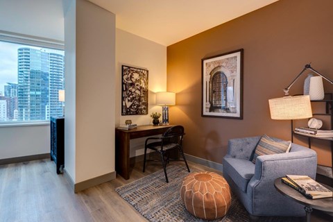 a living room with a couch and a desk and a window