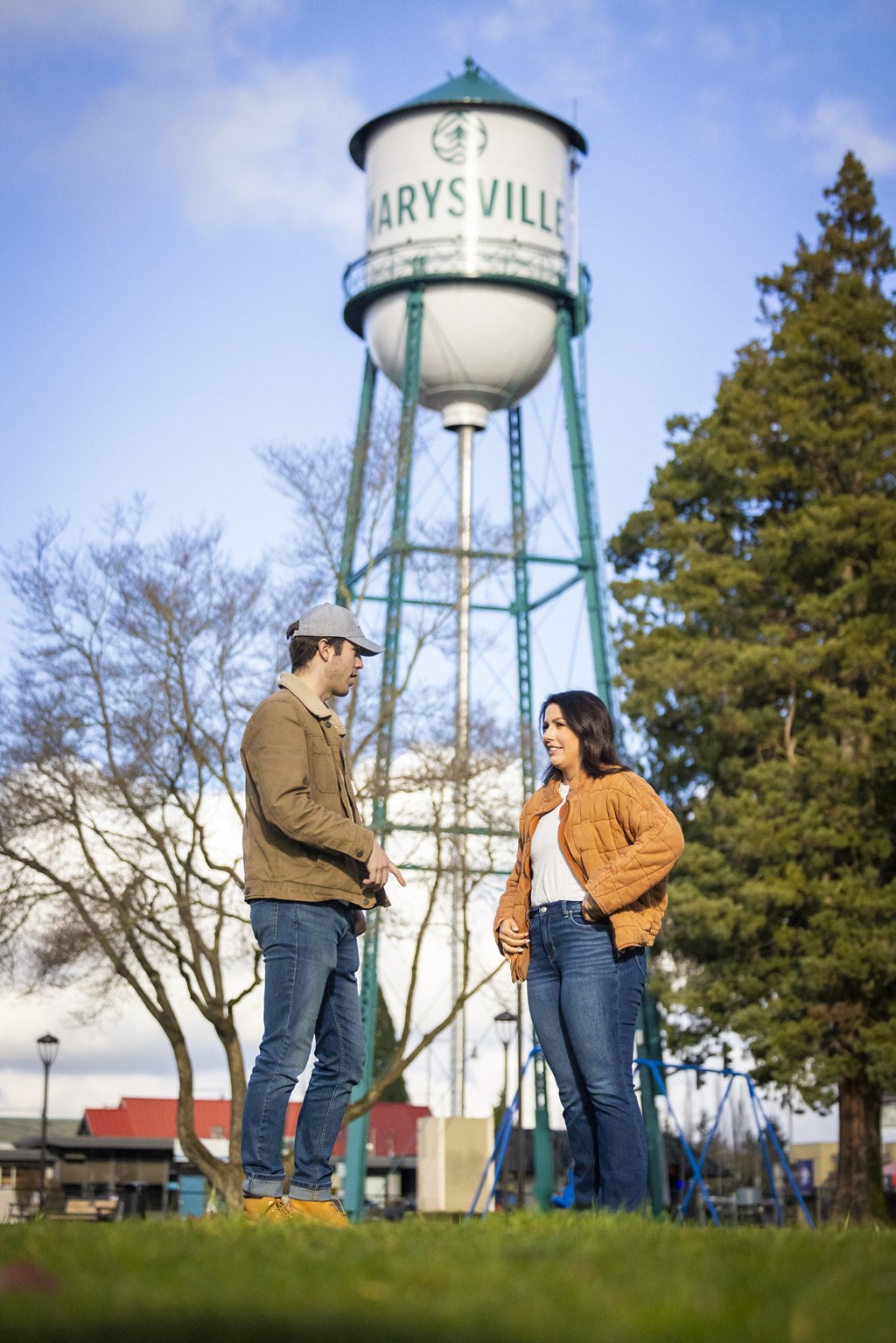 Two people standing in front of a water tower.