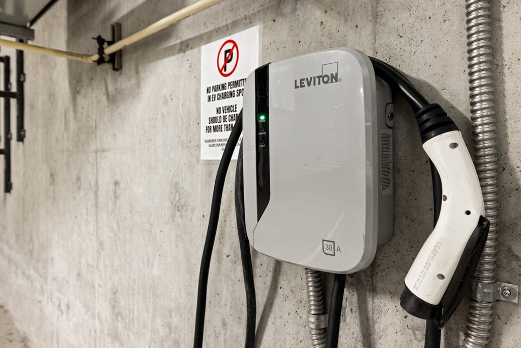 A Leviton electric vehicle charging station is plugged into a wall.