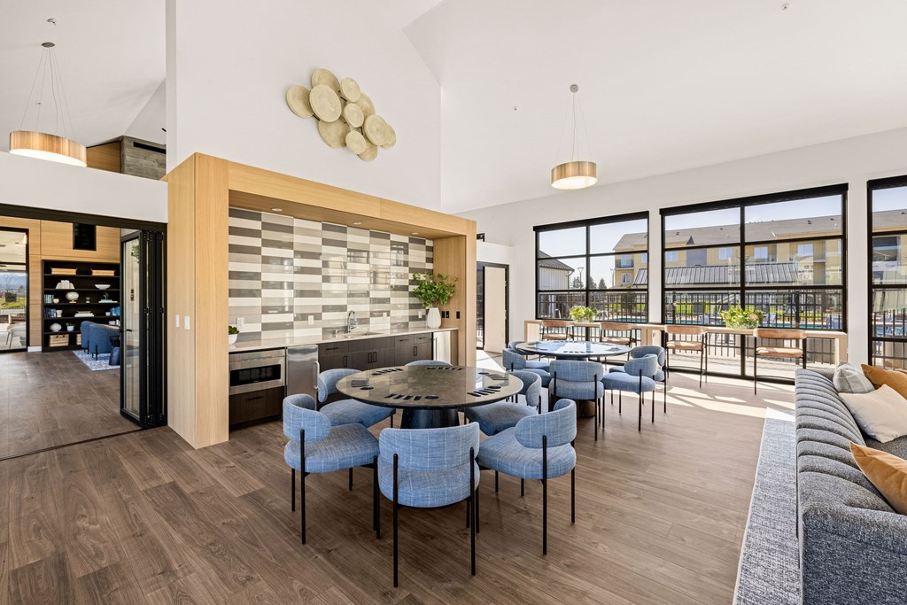 A modern dining room with a large table surrounded by chairs.