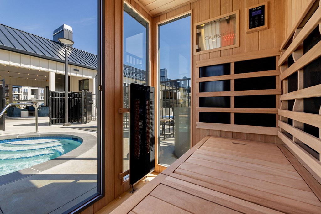 A wooden deck with a glass door leading to a pool area.