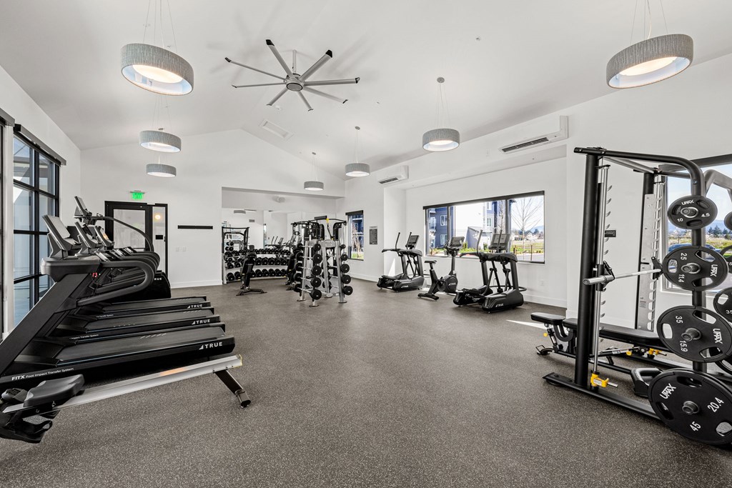 A spacious gym with treadmills, elliptical machines, and weightlifting equipment.