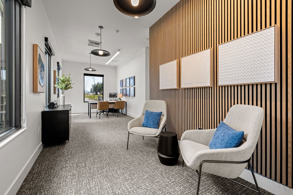 A room with a striped wall and a chair with a blue pillow.