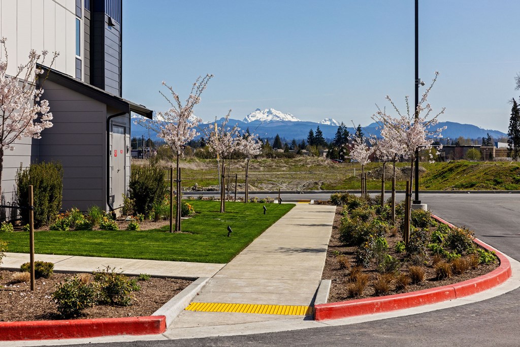 A modern building with a grey exterior and a red and yellow curb in front of it.