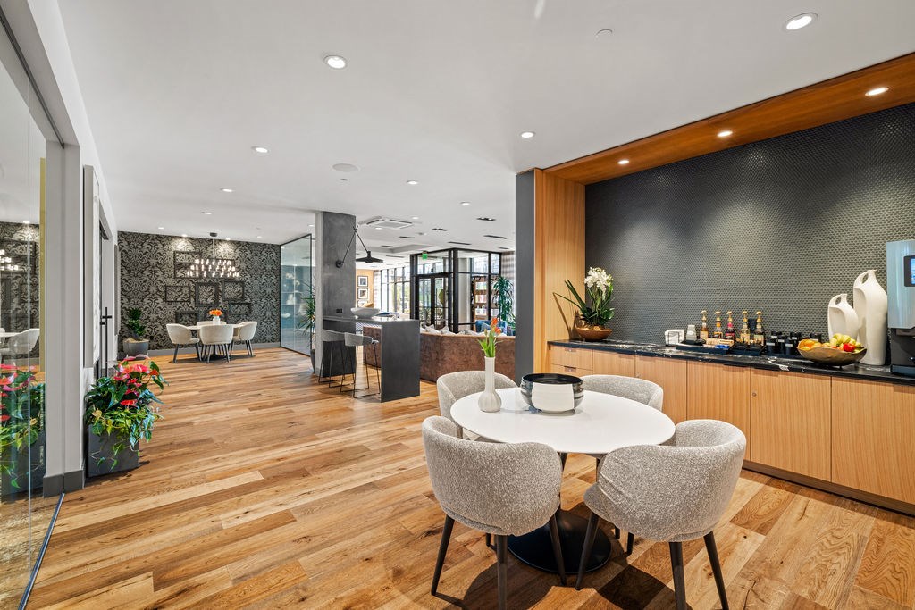 A modern dining room with a round table and grey chairs.