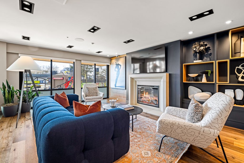 A modern living room with a fireplace and a blue couch.
