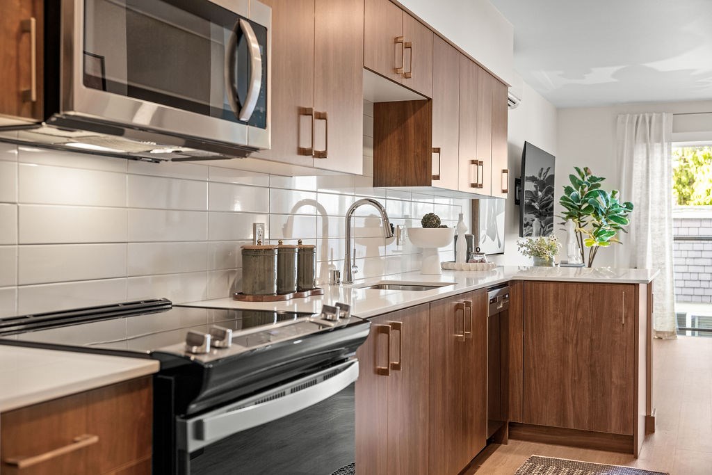 A kitchen with wooden cabinets and a black stove top oven.