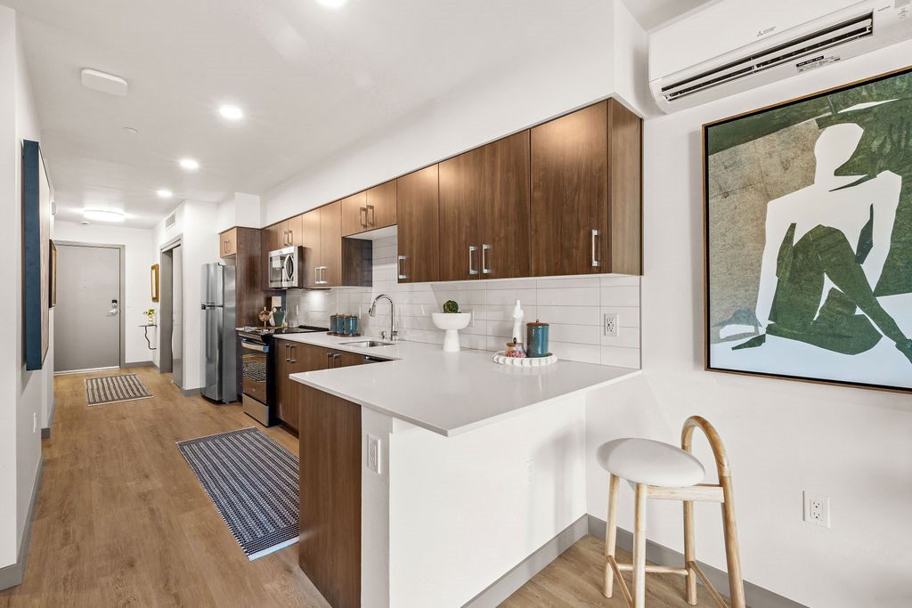 A kitchen with a white counter top and wooden cabinets.