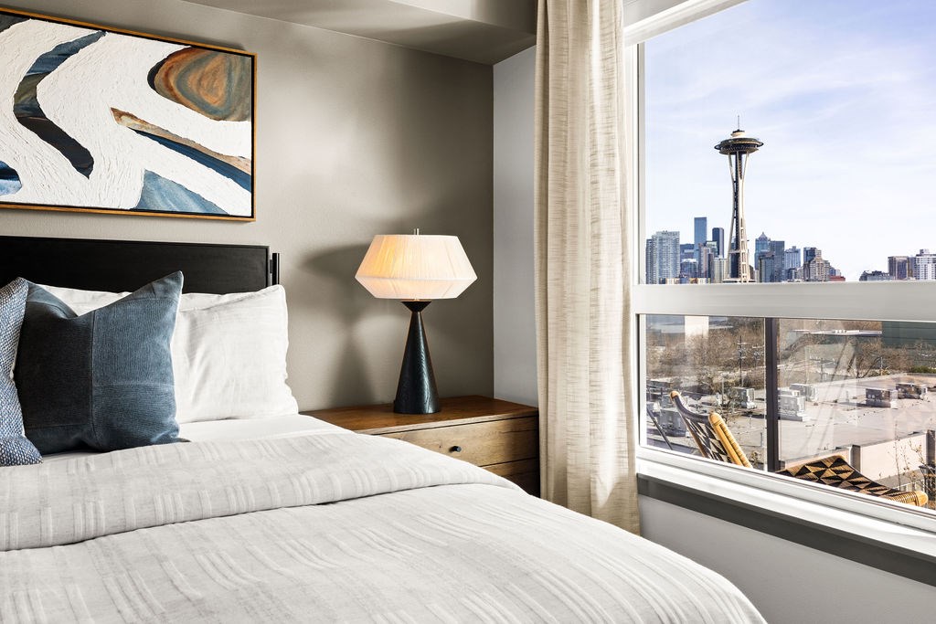 A bedroom with a large bed and a view of the city.