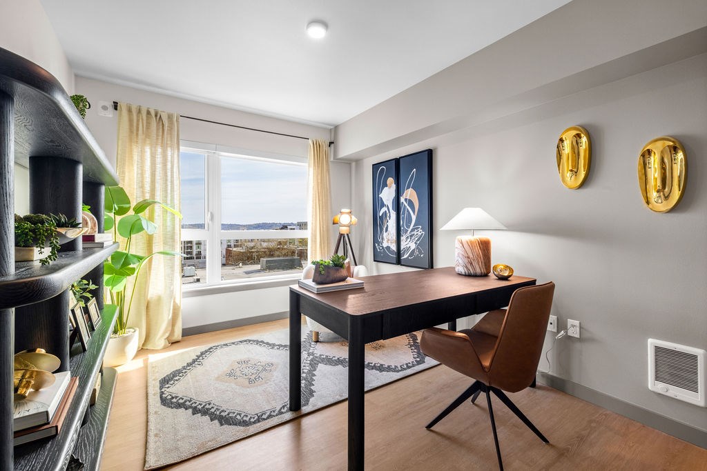 A dining room with a table and chairs and a view of the water.