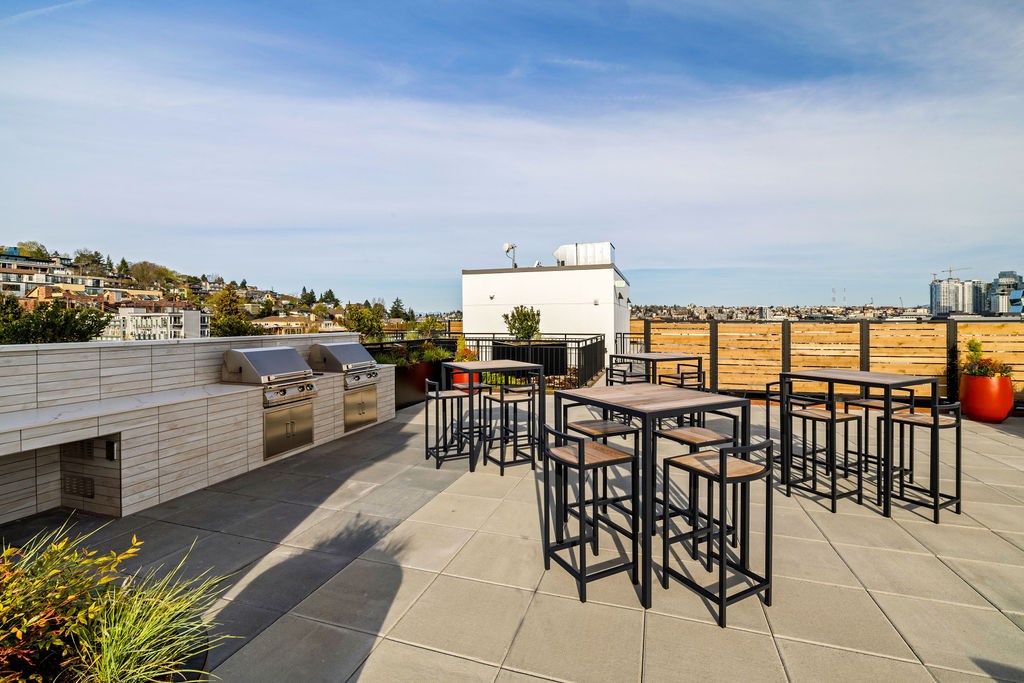 A patio with a table and chairs overlooking a cityscape.