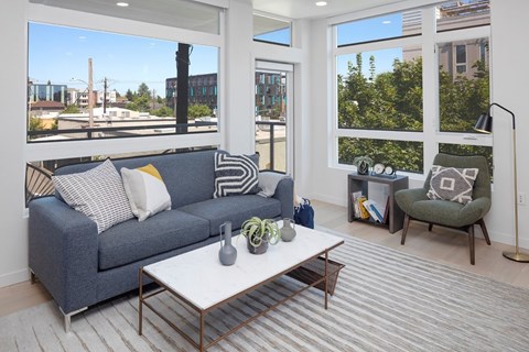 A living room with a grey couch and a white coffee table.