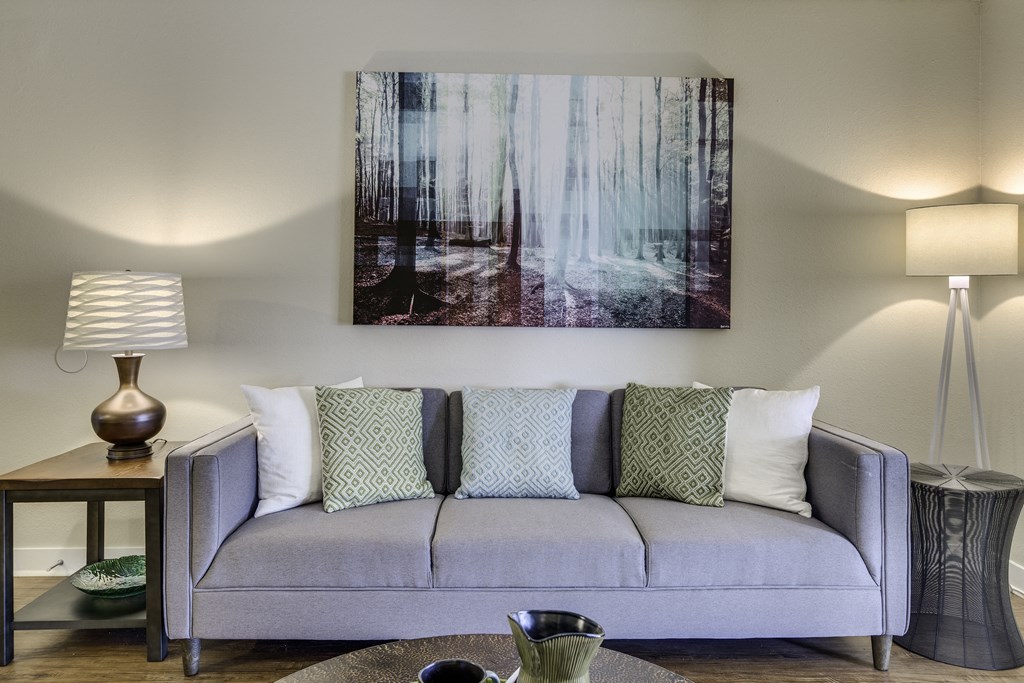 The Reserve at Bucklin Hill Apartments couch with pillows in a living room with a painting on the wall