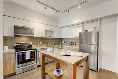 a kitchen with stainless steel appliances and a wooden table
