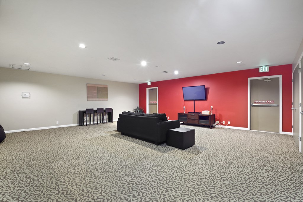 a large living room with a red wall and black furniture