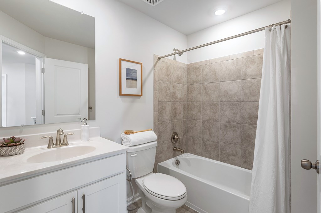 A white bathroom with a toilet, sink, and bathtub.