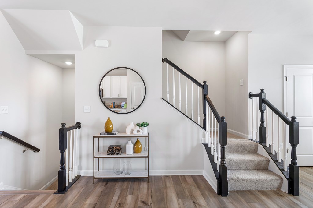 A staircase with a round mirror above it.
